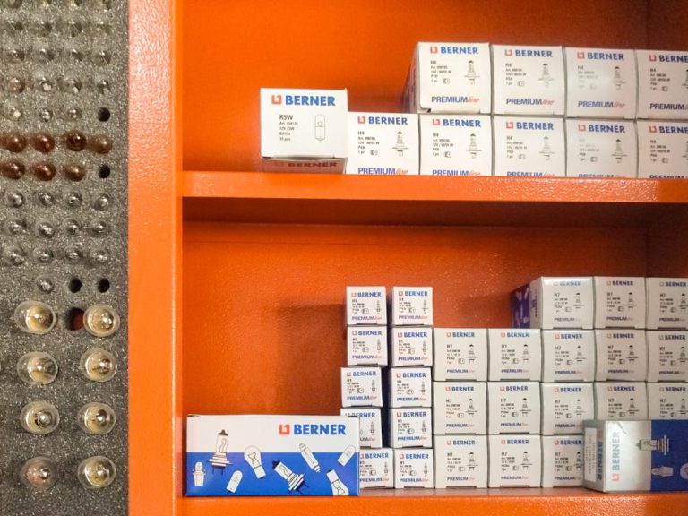 Estantes con cajas de bombillas para vehículos organizadas en diferentes tamaños.